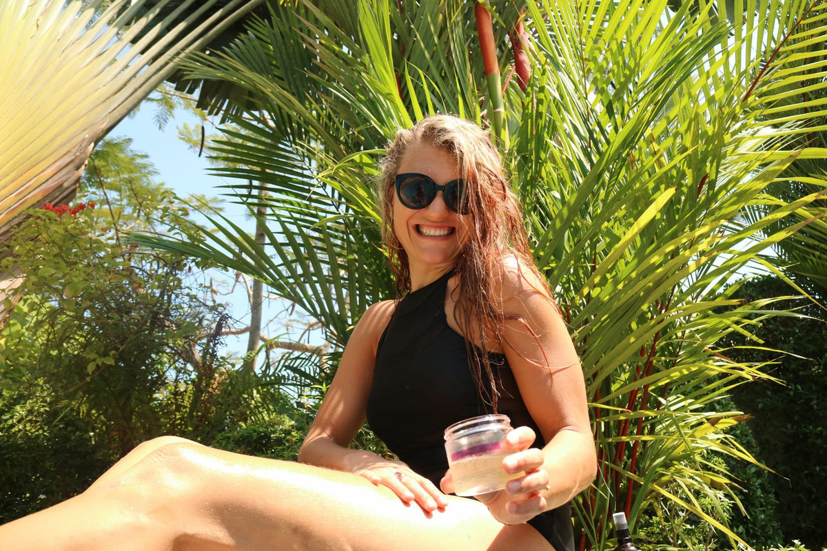 2. Woman in black swimsuit holding HOIA homespa Monoi de Tahiti Body Butter by the poolside