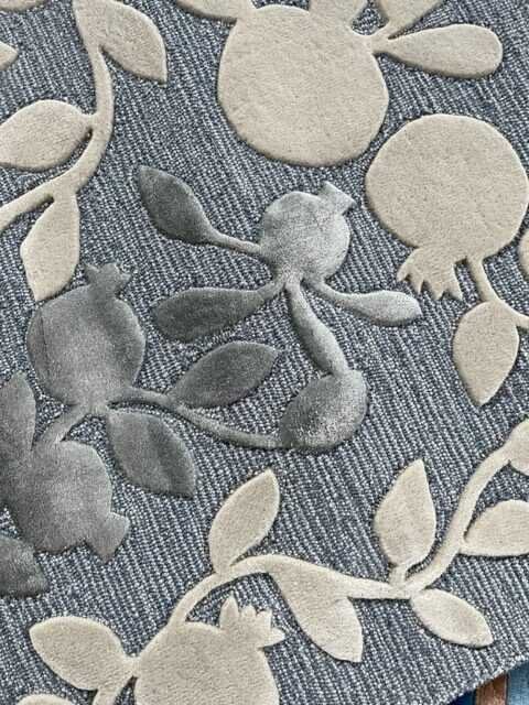 3. Close-up of beige and grey pomegranate design on blue wool rug