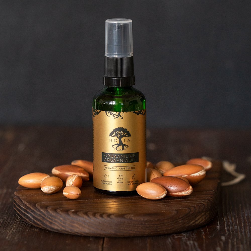 3. Studio shot of HOIA homespa Organic Argan Oil bottle with argan nuts, emphasizing natural ingredients