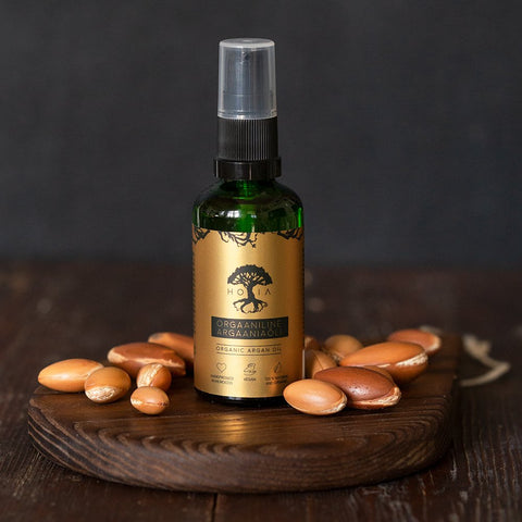 3. Studio shot of HOIA homespa Organic Argan Oil bottle with argan nuts, emphasizing natural ingredients