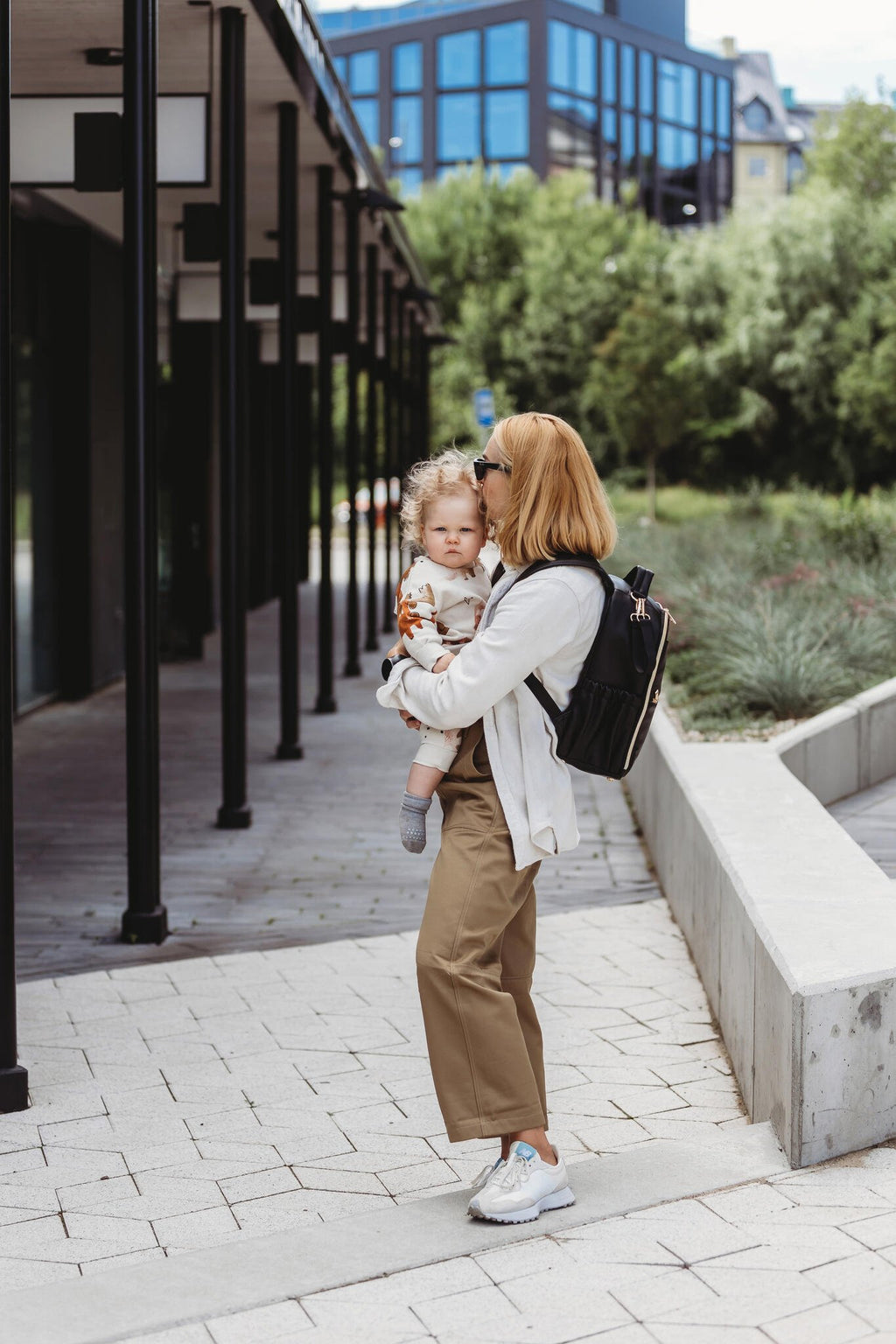 2. Woman wearing Ally Scandic Small Espresso Diaper Backpack while walking