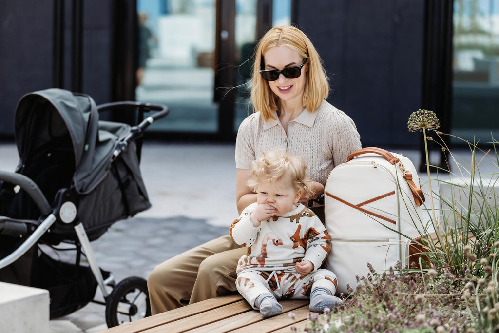 1. Woman with child using Ally Scandic Cappuccino Diaper Backpack, showcasing hands-free convenience