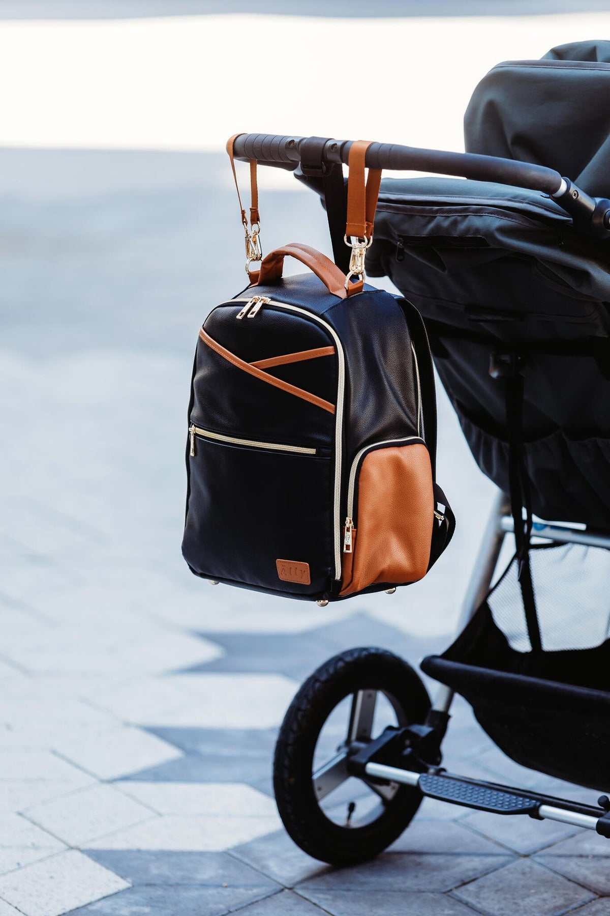 15. Ally Scandic Small Diaper Backpack in Black Coffee attached to stroller outdoors