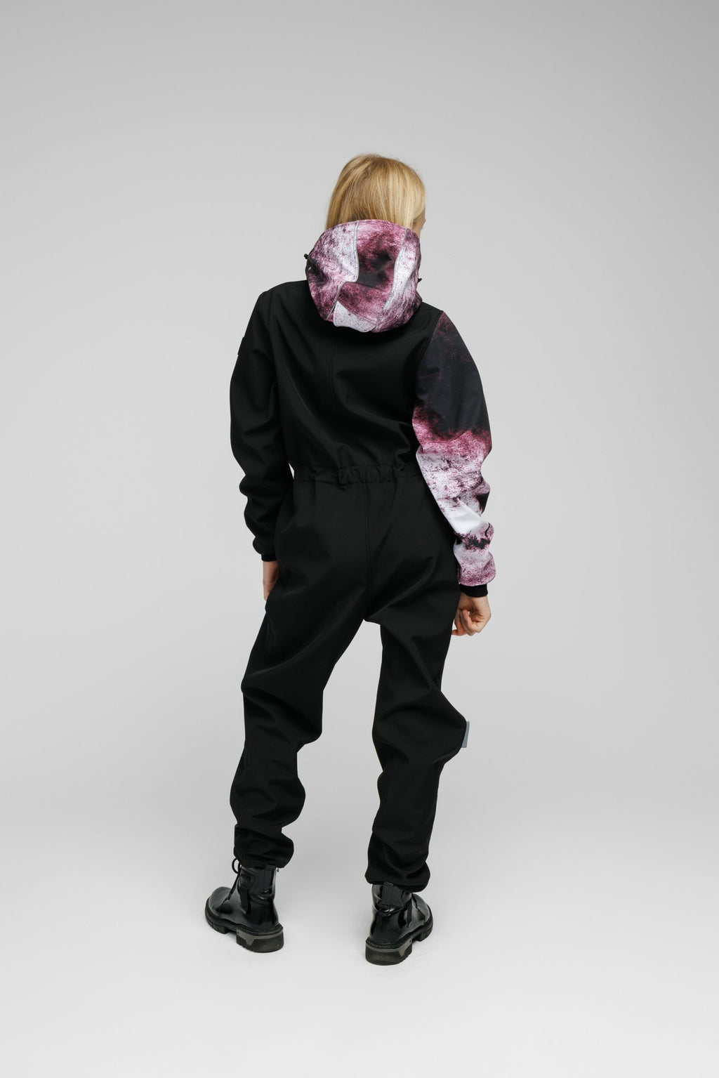 4. Back view of Nuckö Pilv softshell onesie worn by girl, showing ribbed cuffs and legs