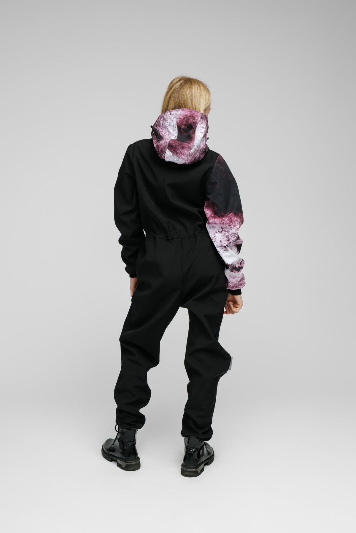 4. Back view of Nuckö Pilv softshell onesie worn by girl, showing ribbed cuffs and legs