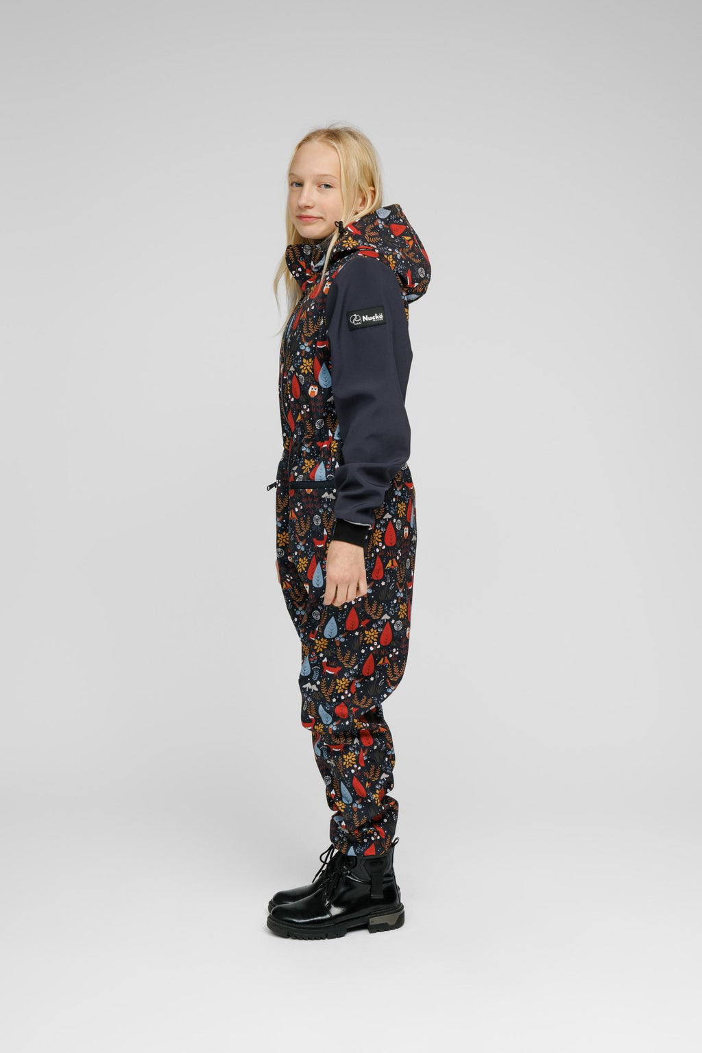 9. Child in Nuckö softshell onesie with forest print, side profile in studio