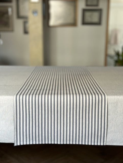 3. Studio shot of Nord 1 table runner with blue stripes by Hortensias Home, displayed on a table