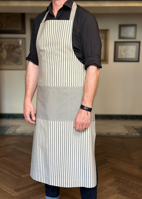 2. Unisex Nord 1 apron by Hortensias Home worn by male model, highlighting striped design and multiple pockets