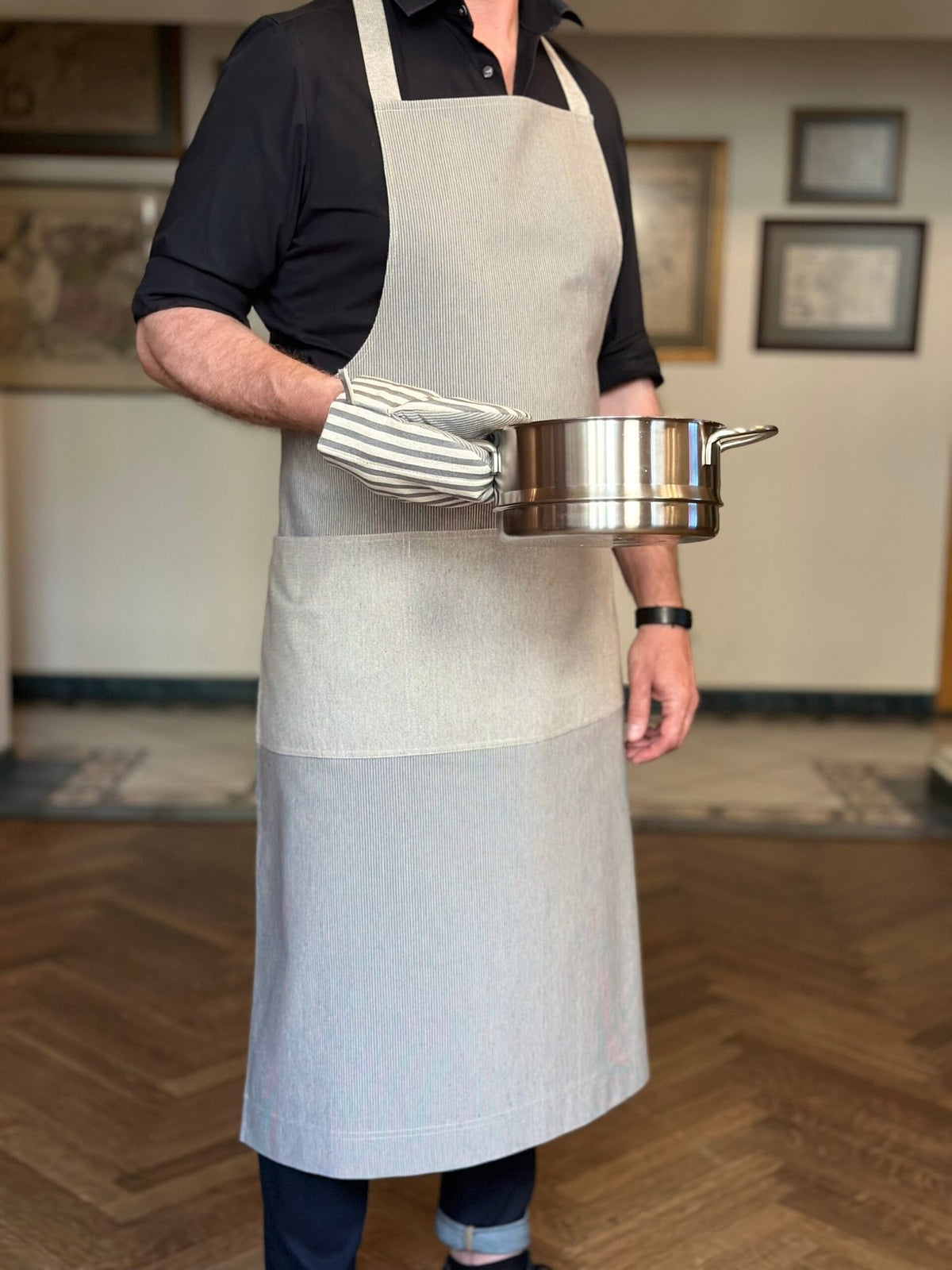 2. Man wearing Hortensias Home Nord 2 unisex apron, holding a pot, highlighting recycled fabric and Scandinavian design, lifestyle setting