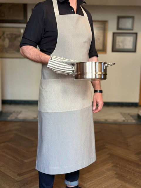 2. Man wearing Hortensias Home Nord 2 unisex apron, holding a pot, highlighting recycled fabric and Scandinavian design, lifestyle setting