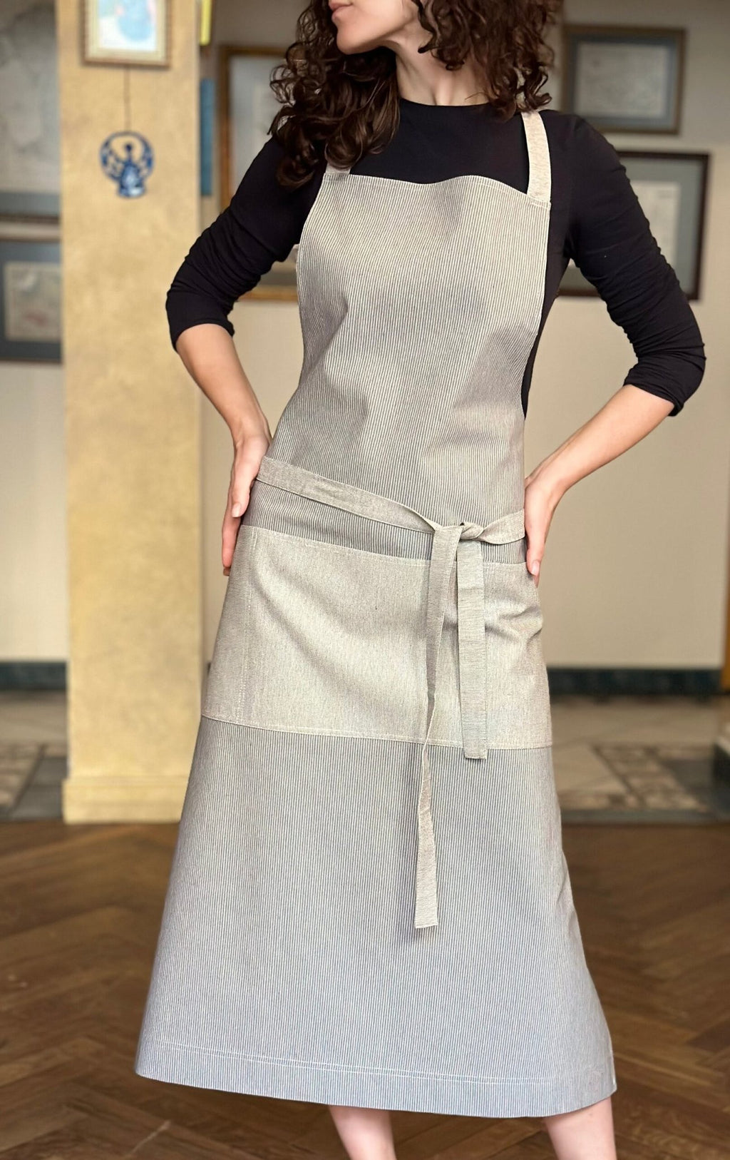 1. Woman wearing Hortensias Home Nord 2 unisex apron in Scandinavian style, showcasing recycled fabric and multiple pockets, lifestyle setting