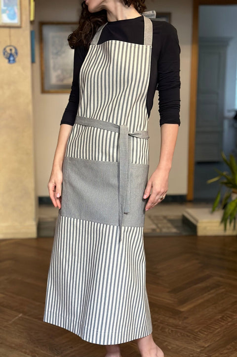 1. Unisex Nord 1 apron by Hortensias Home worn by female model, showcasing Scandinavian style in kitchen setting