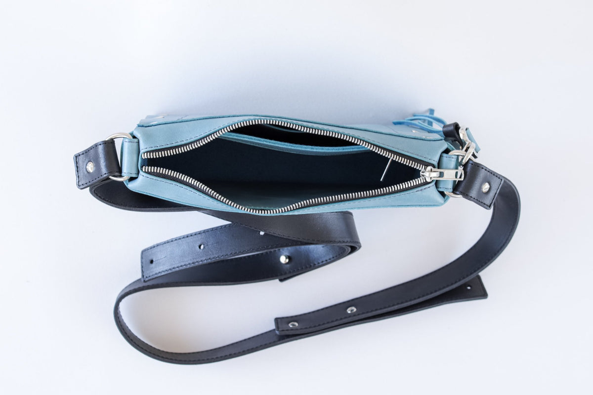 13. Top view of eleriinseim TOURIST crossbody leather bag in Capri blue, showing open zippered closure and adjustable strap
