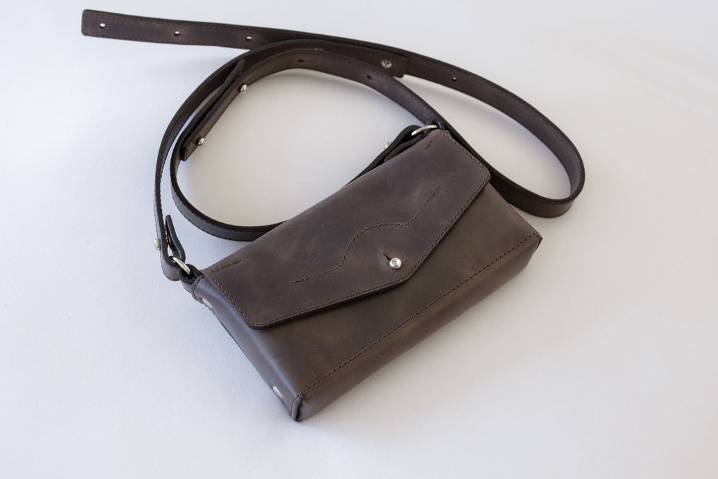 9. Studio shot of KOKUKA crossbody leather bag in brown, highlighting adjustable strap and minimalist design