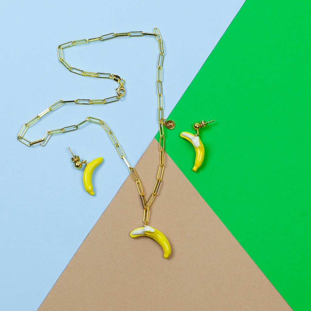 3. Flat lay of SCULP Banana Love earrings and matching necklace on colorful background