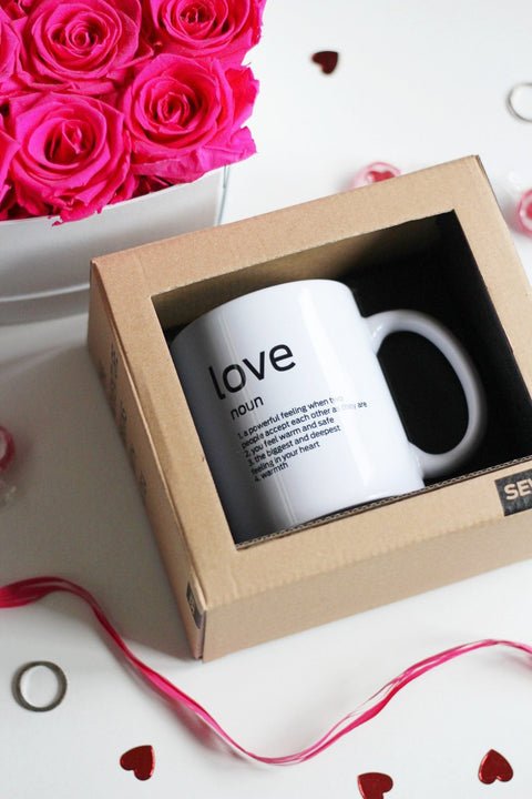 2. SEIK Design Mug with 'Love' definition in packaging, surrounded by pink roses and heart-shaped decor