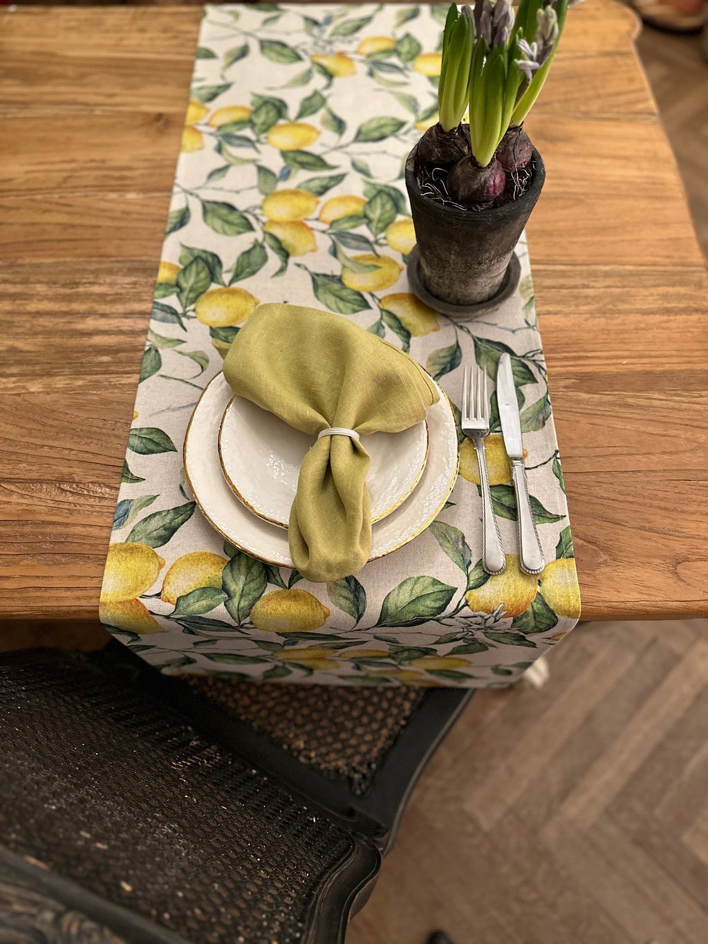 1. Lemon Linen Table Runner by Hortensias Home on wooden dining table with green napkin and white plate setting