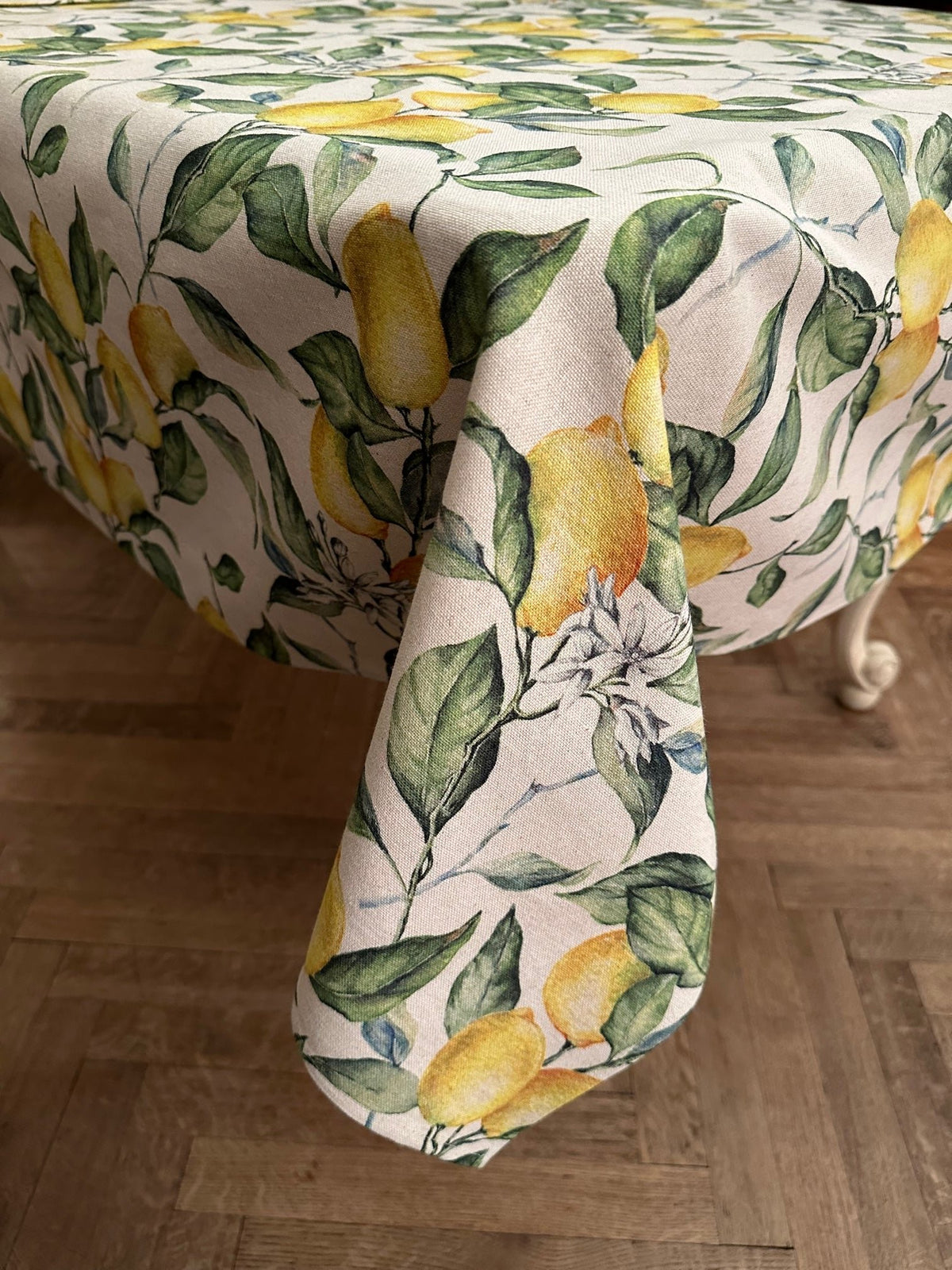 2. Side view of Hortensias Home Lemon Linen tablecloth draped over table, showcasing lemon print