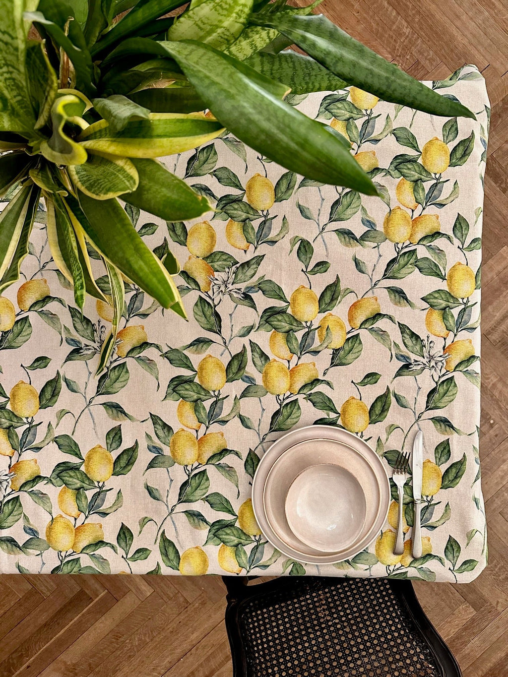 1. Top view of Hortensias Home Lemon Linen rectangular tablecloth on dining table with plant and tableware