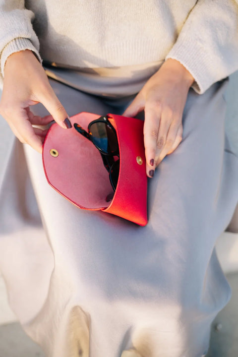 3. Close-up of Mirgoods red leather sunglasses case with sunglasses inside