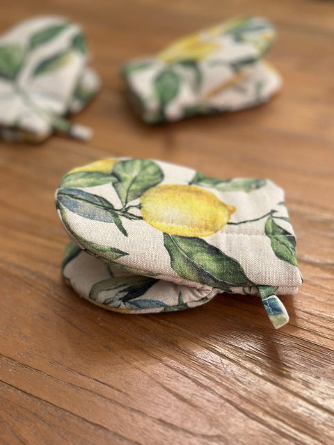 1. Close-up of Hortensias Home Lemon Linen oven glove with lemon print, showcasing double wool filling on wooden surface