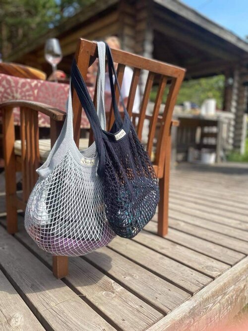 1. Organic cotton string bags by Sidrunid in grey and black, hanging on a wooden chair outdoors