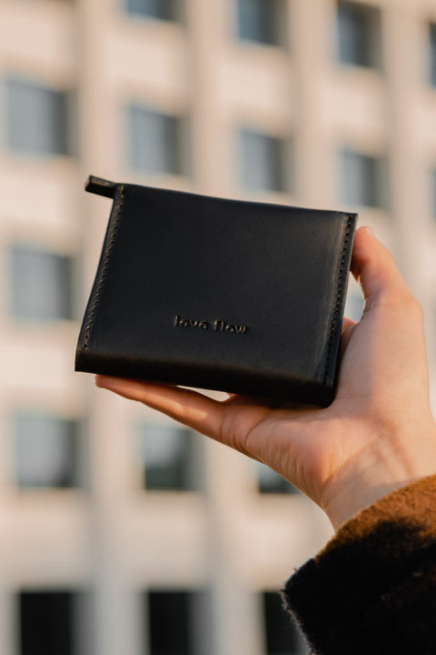 3. Lava flow Classic Leather Wallet MINI TAAL in black held outdoors, emphasizing stylish design and brand logo