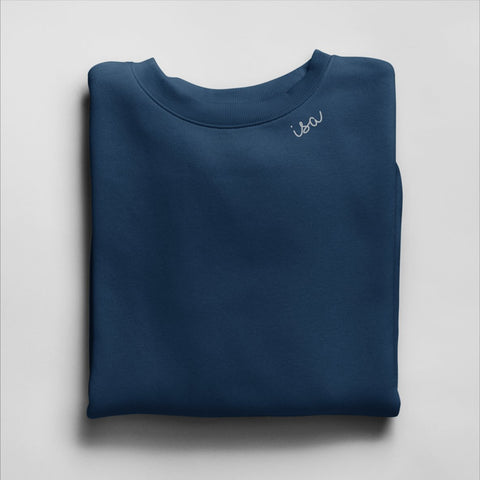 3. Navy Beebila sweatshirt with 'Isa' embroidery on collar, folded in studio setting
