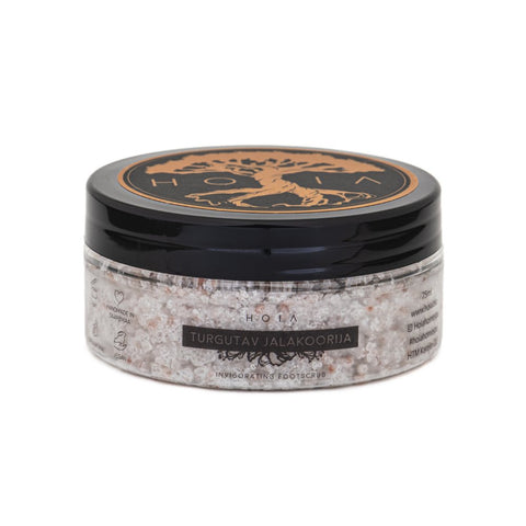 2. HOIA homespa Revitalizing Foot Scrub jar on wooden board with juniper berries and rosemary, highlighting natural ingredients