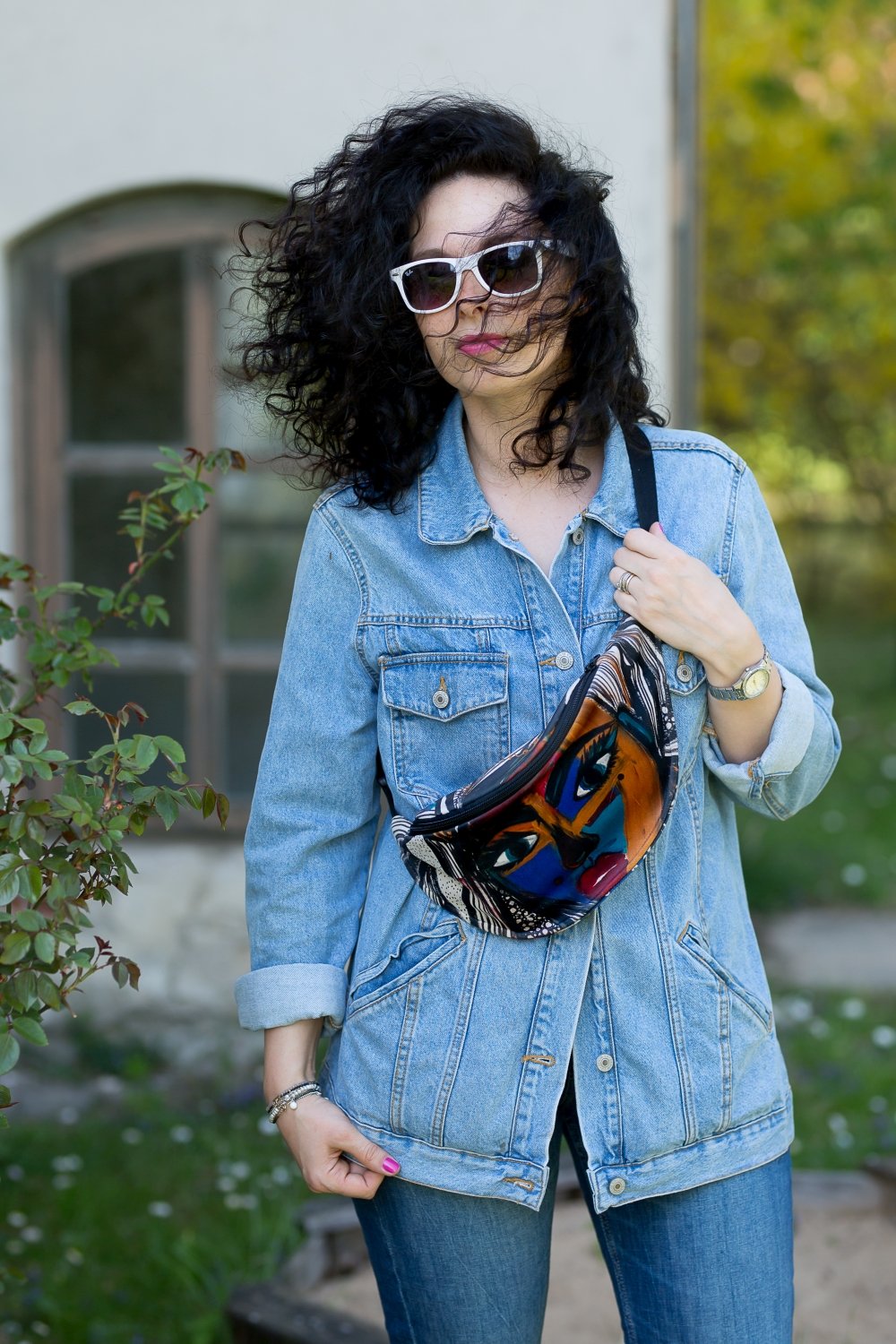 1. Woman wearing Garbanota Fanny Pack Mermaid with unique mermaid print, styled with denim jacket outdoors