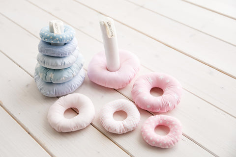 2. Blue and pink Karloova stacking towers with rings laid flat on white wooden floor