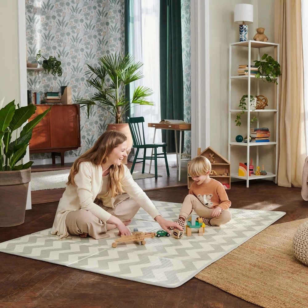 13. Woman playing with older child on large chevron-patterned playmat in stylish living room