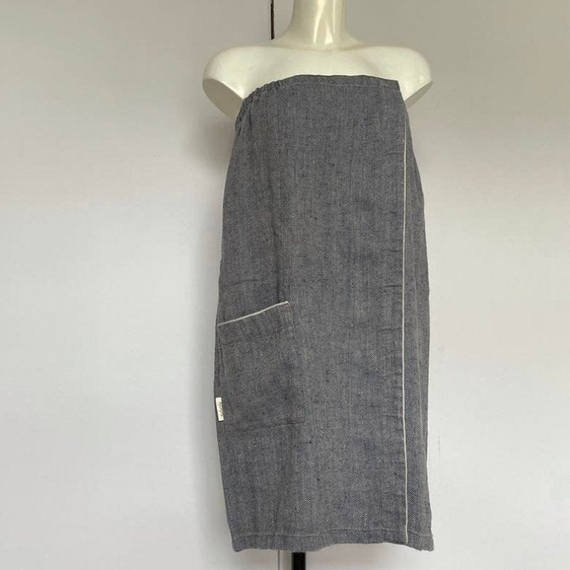 2. Women's grayish blue linen sauna skirt with fishbone pattern displayed on a mannequin in a studio setting