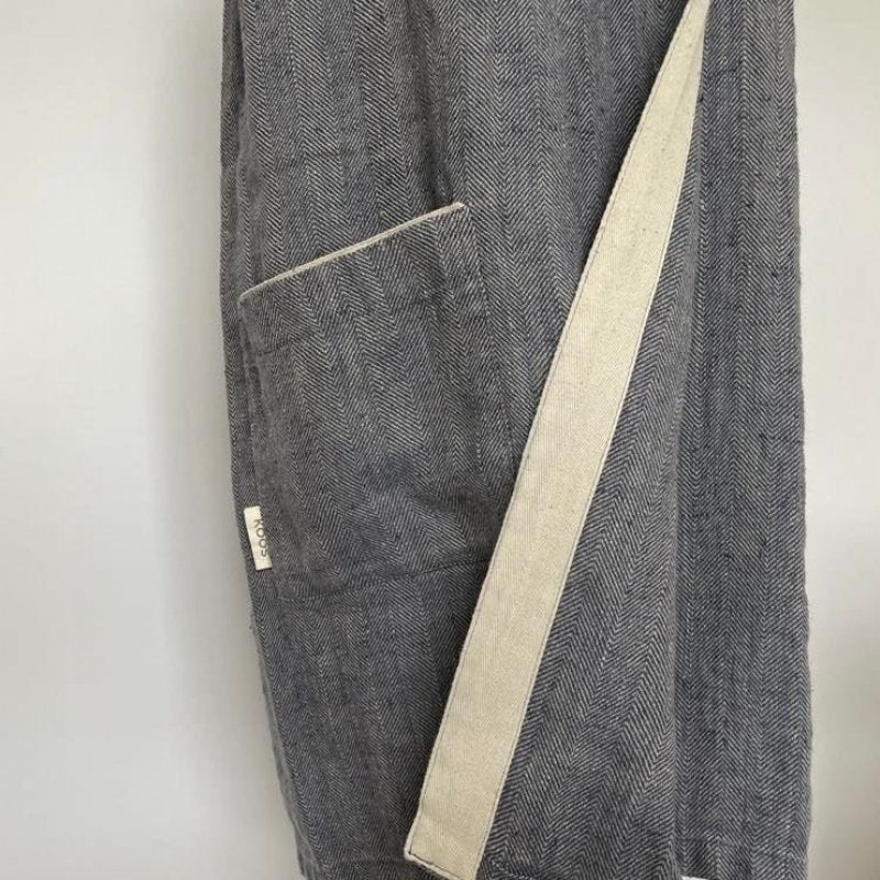 3. Close-up of pocket and KOOSdisain label on women's grayish blue linen sauna skirt with fishbone pattern