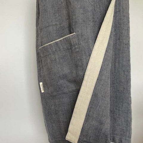 3. Close-up of pocket and KOOSdisain label on women's grayish blue linen sauna skirt with fishbone pattern