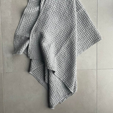3. Draped gray waffle fabric towel on concrete floor showing texture and size