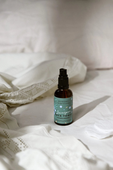 1. BONOBO Juniper Face Tonic bottle on a bed, showcasing natural skincare packaging