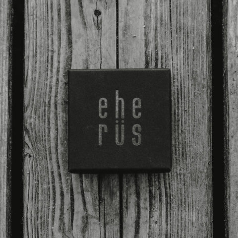 2. Black gift box with 'Eherüs' logo in white, placed on rustic wooden surface