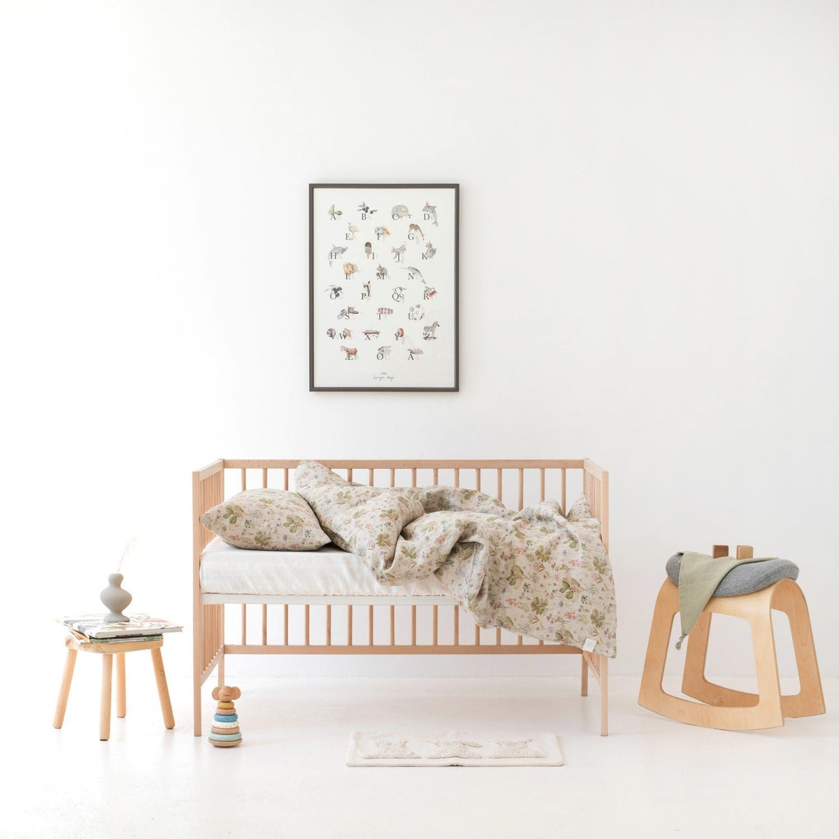 1. Kids' room with botanical print linen duvet cover set on bed, wooden crib, and decor