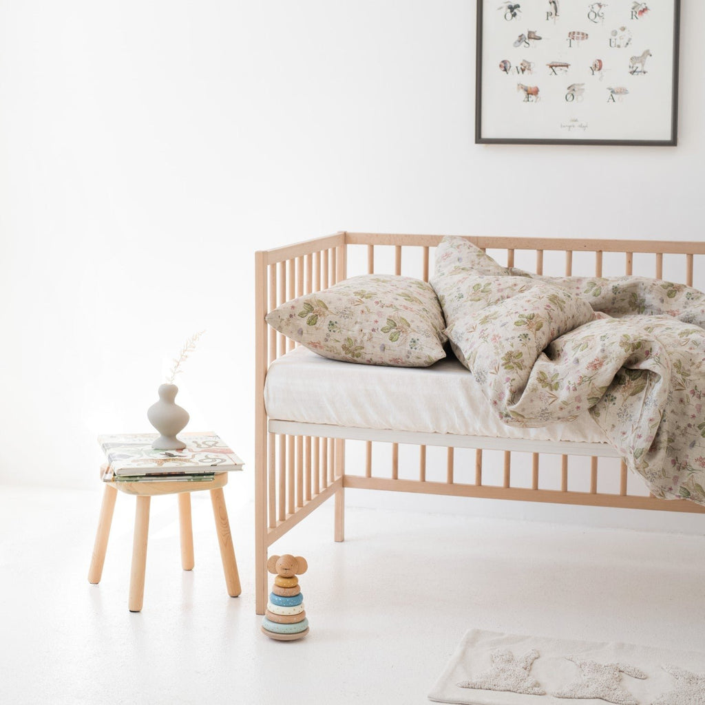 1. Kids' bed with botanical print linen duvet cover set, wooden crib, and decor in bright room
