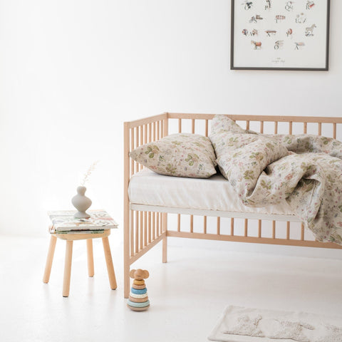 1. Kids' bed with botanical print linen duvet cover set, wooden crib, and decor in bright room