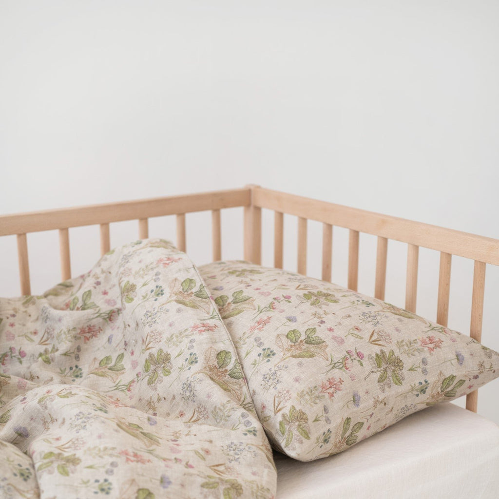 2. Botanical print linen duvet cover and pillowcase on kids' bed in wooden crib