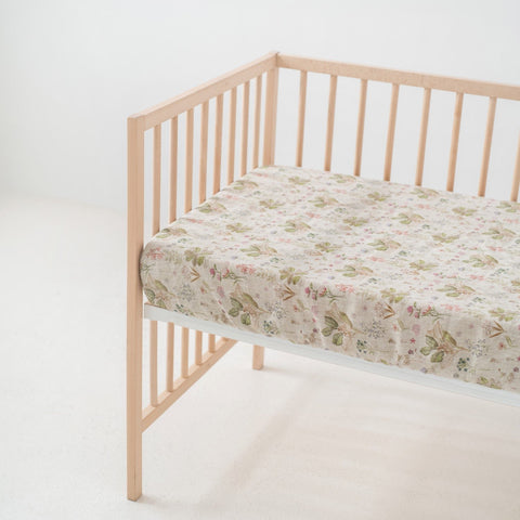 1. Kids sage linen fitted sheet with floral print on crib mattress in a light wooden crib