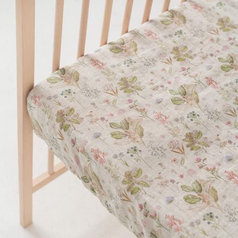 4. Close-up of floral linen fitted sheet on crib mattress with wooden crib slats