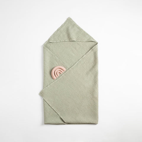 5. Flat lay of sage green linen hooded towel with pink toy on white background
