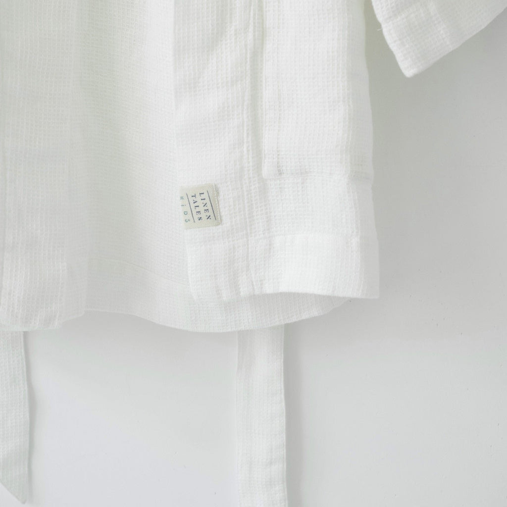 3. Close-up of white linen bathrobe showing Linen Tales label and waffle texture