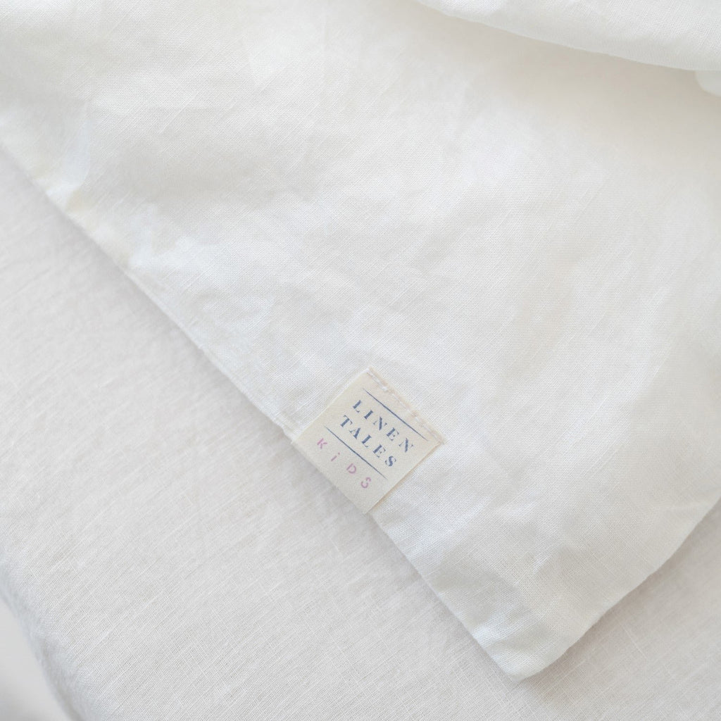 3. Close-up of Linen Tales brand label on white linen fabric