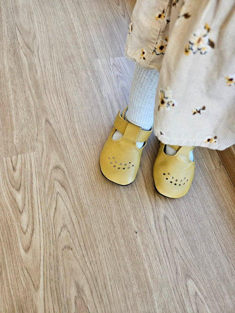 3. Close-up of Omaking yellow Mutsu slippers on child's feet, showing adjustable Velcro fastener