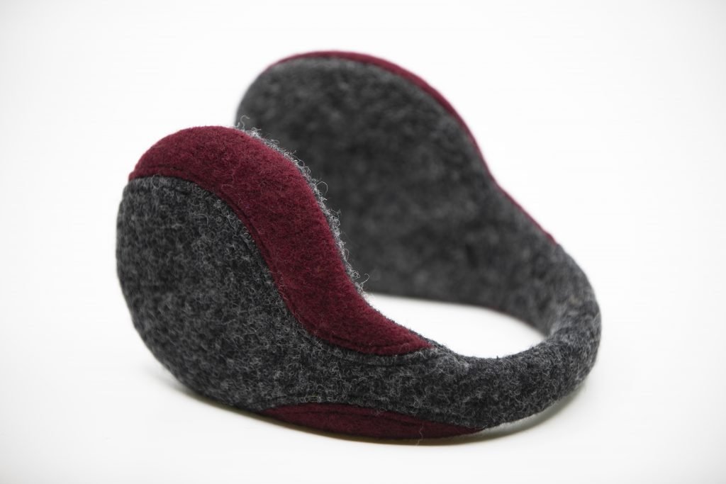 2. Close-up of HERTTA felted wool earmuffs in dark grey and bordeaux, highlighting wool fabric and craftsmanship