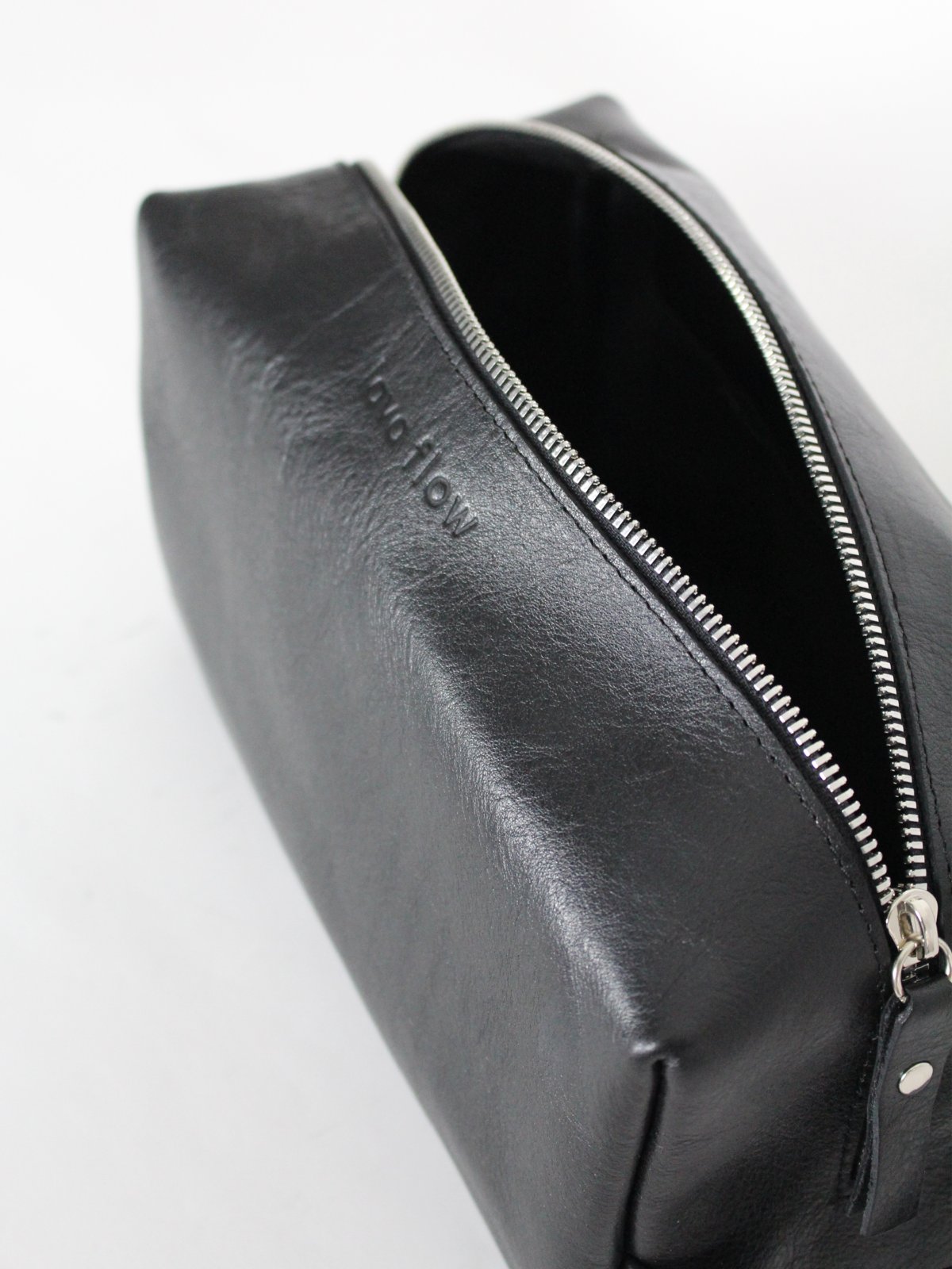 2. Close-up of Lava flow VESUVIUS black cosmetic bag highlighting zippered opening and leather texture